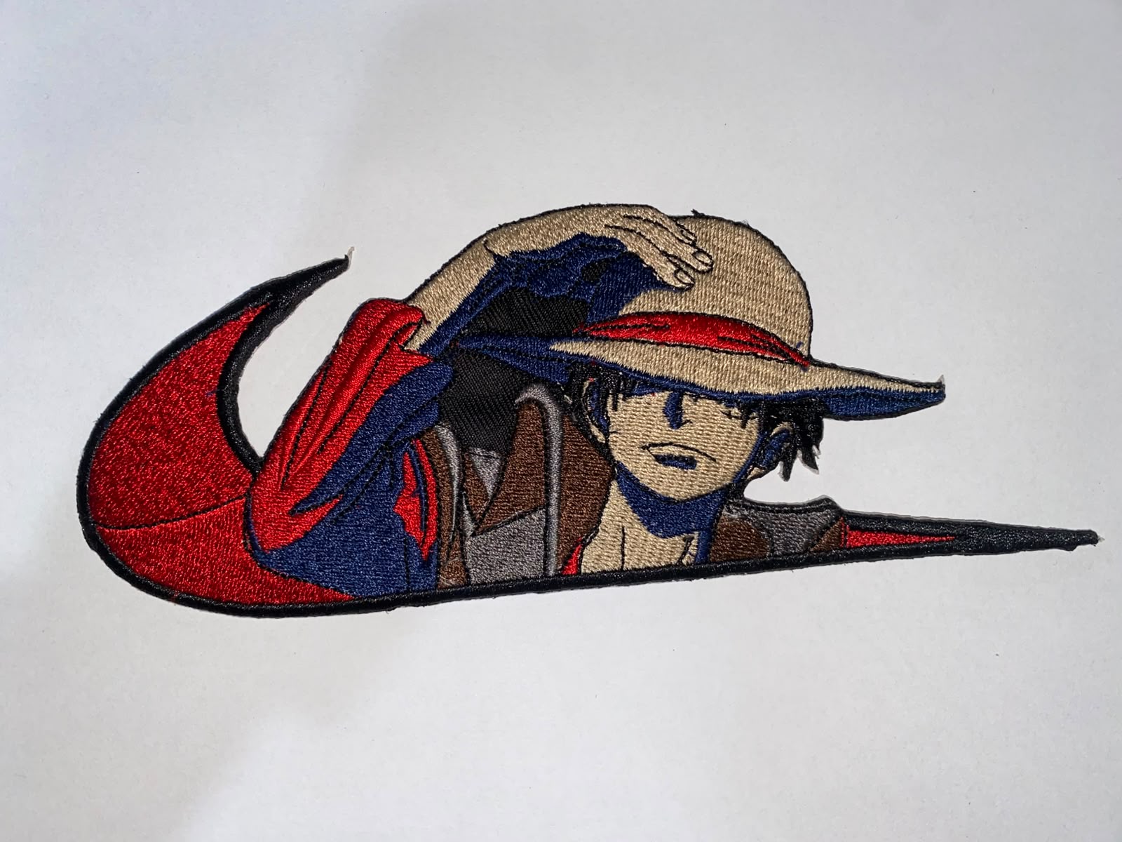 Multi-colour character embroidery patch shaped as a sport logo swoosh
