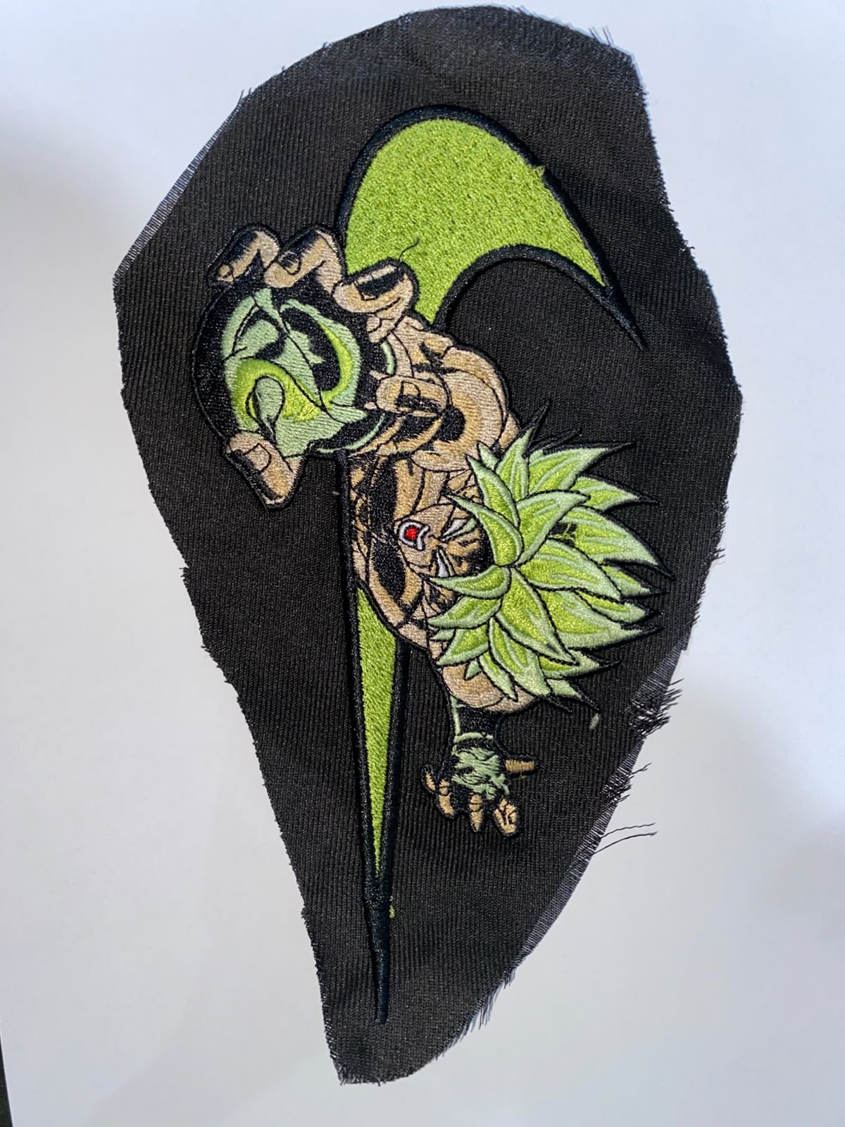 Green and black heavy fill embroidery panel stitched on denim fabric