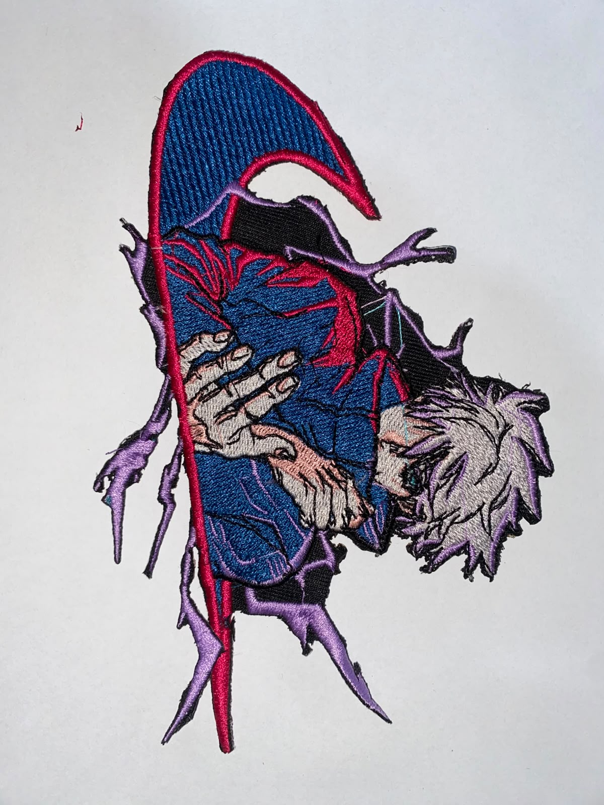 Detailed multi-thread character embroidery patch in blue and violet threads